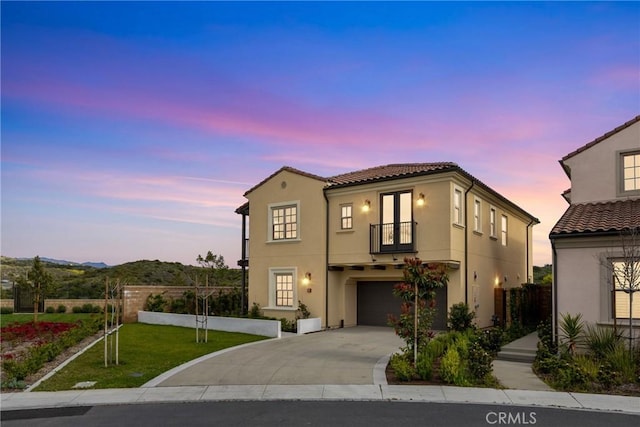 200 Canterbury, Irvine, CA 92618 - mediterranean / spanish-style house featuring a balcony, stucco siding, a garage, driveway, and a tile roof