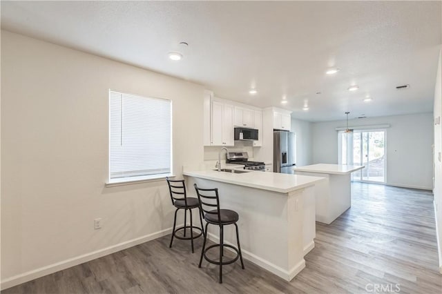 1325 Deodara Way, Paradise, CA 95969 - kitchen with appliances with stainless steel finishes, light wood-style flooring, a kitchen island, baseboards, and light countertops