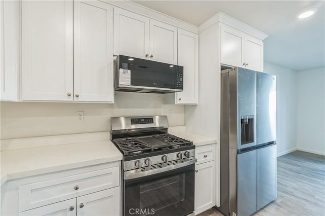 1325 Deodara Way, Paradise, CA 95969 - kitchen with appliances with stainless steel finishes, white cabinetry, light wood finished floors, light stone counters, and baseboards