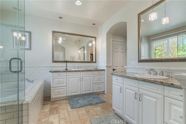 36702 Doreen Dr, Murrieta, CA 92563 - bathroom featuring tile walls, two vanities, a bath, a stall shower, and wainscoting