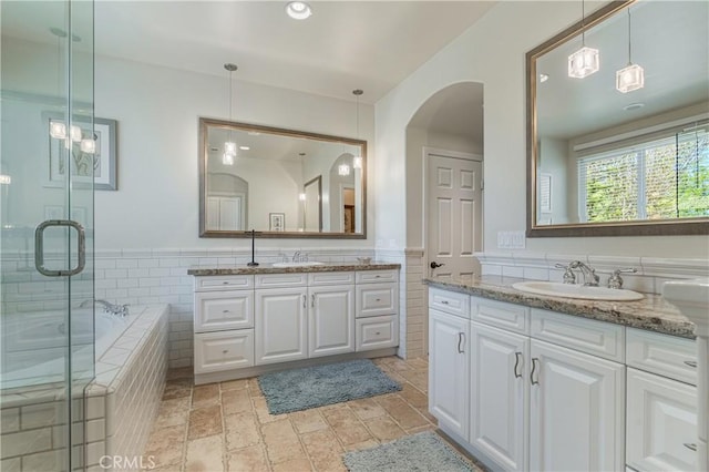 36702 Doreen Dr, Murrieta, CA 92563 - bathroom featuring tile walls, two vanities, a bath, a stall shower, and wainscoting