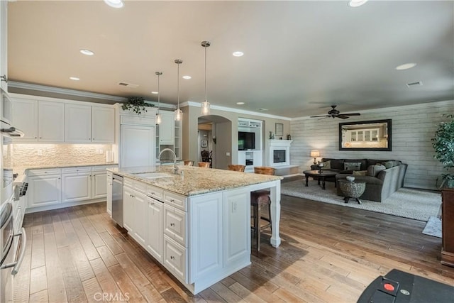 36702 Doreen Dr, Murrieta, CA 92563 - kitchen featuring a sink, a ceiling fan, arched walkways, a kitchen breakfast bar, and white cabinets