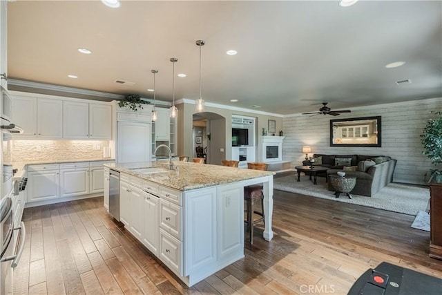36702 Doreen Dr, Murrieta, CA 92563 - kitchen with ceiling fan, arched walkways, a breakfast bar, stainless steel dishwasher, and white cabinets
