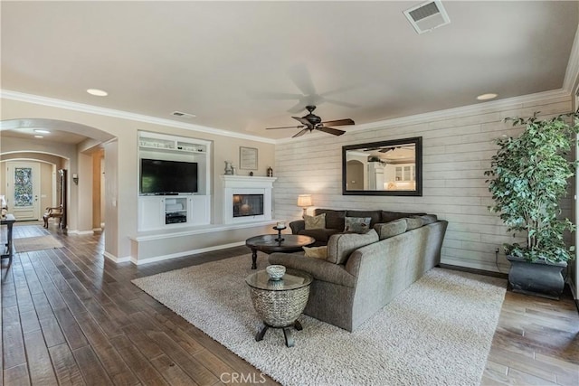 36702 Doreen Dr, Murrieta, CA 92563 - living room featuring arched walkways, a ceiling fan, dark wood-type flooring, wood walls, and crown molding