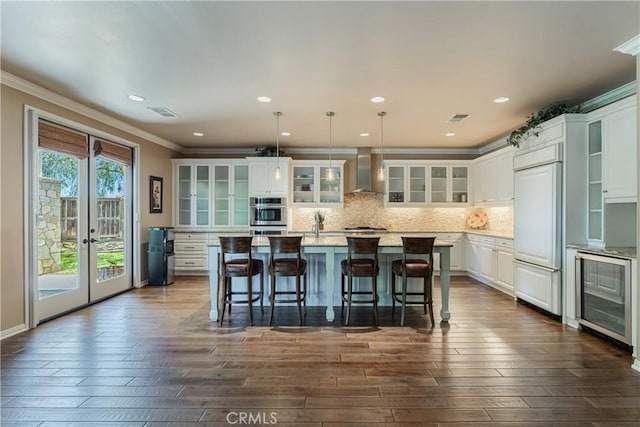 36702 Doreen Dr, Murrieta, CA 92563 - kitchen featuring wall chimney exhaust hood, wine cooler, crown molding, dark wood-type flooring, and white cabinetry