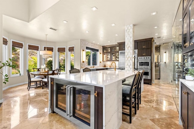 9698 Welk View Dr, Escondido, CA 92026 - kitchen featuring beverage cooler, stainless steel appliances, glass insert cabinets, dark brown cabinetry, and light marble finish flooring