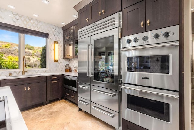 9698 Welk View Dr, Escondido, CA 92026 - kitchen featuring appliances with stainless steel finishes, light countertops, dark brown cabinetry, and backsplash