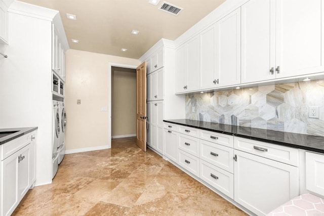 9698 Welk View Dr, Escondido, CA 92026 - kitchen featuring washing machine and clothes dryer, dark countertops, backsplash, and white cabinetry