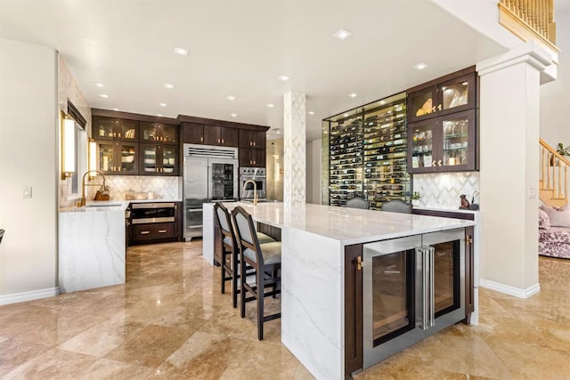 9698 Welk View Dr, Escondido, CA 92026 - indoor bar with wine cooler, stainless steel appliances, decorative backsplash, light marble finish flooring, and stairs