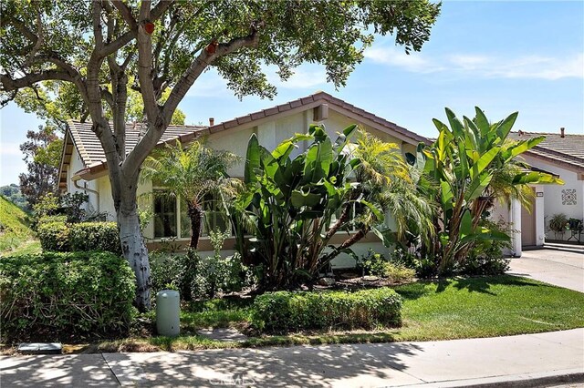 27972 Via Chocano, Mission Viejo, CA 92692 - obstructed view of property featuring a tile roof, stucco siding, driveway, and an attached garage