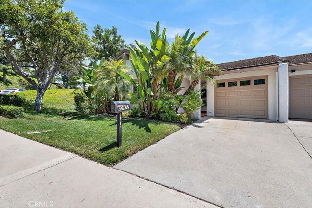27972 Via Chocano, Mission Viejo, CA 92692 - view of front of house featuring concrete driveway, a front lawn, a garage, stucco siding, and a tile roof