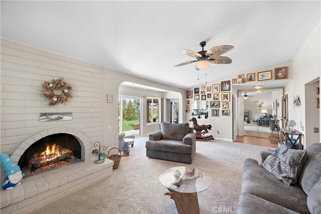 27972 Via Chocano, Mission Viejo, CA 92692 - carpeted living area with ceiling fan, a brick fireplace, arched walkways, lofted ceiling, and baseboards