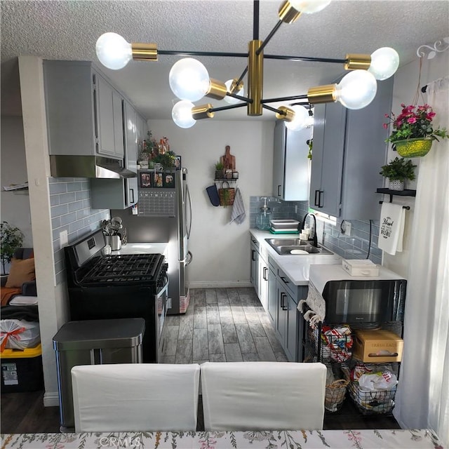 9754 5th Ave, Hesperia, CA 92345 - kitchen with stainless steel appliances, a sink, light wood-type flooring, backsplash, and light countertops