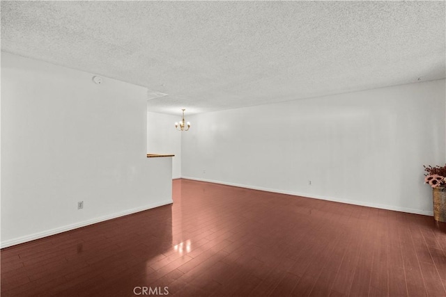 2300 S Hacienda Blvd Unit F8, Hacienda Heights, CA 91745 - empty room featuring a chandelier, dark wood-type flooring, a textured ceiling, and baseboards