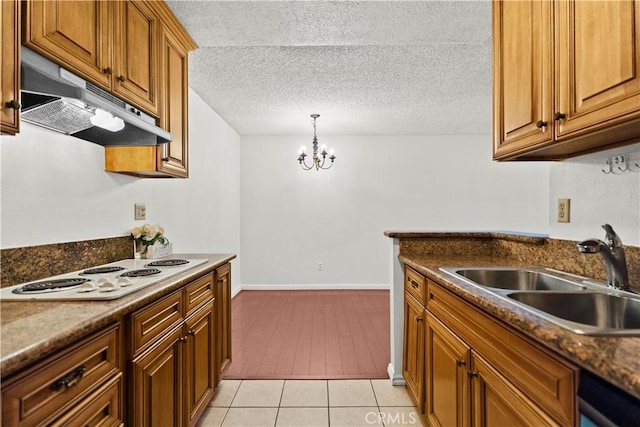 2300 S Hacienda Blvd Unit F8, Hacienda Heights, CA 91745 - kitchen featuring under cabinet range hood, white electric cooktop, a sink, a chandelier, and brown cabinetry