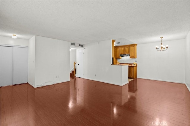 2300 S Hacienda Blvd Unit F8, Hacienda Heights, CA 91745 - unfurnished living room featuring a textured ceiling, a chandelier, wood finished floors, stairway, and baseboards