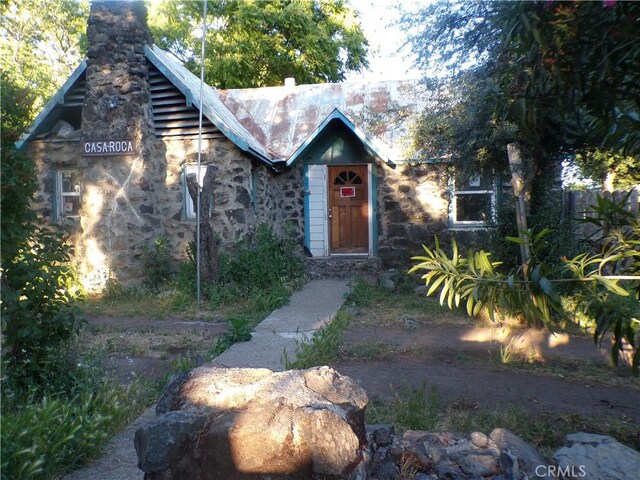 3688 Koloko St, Clearlake, CA 95422 - view of front of home with a chimney, stone siding, and metal roof