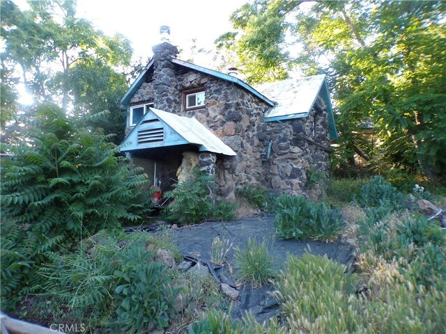 3688 Koloko St, Clearlake, CA 95422 - view of home's exterior featuring stone siding and a chimney