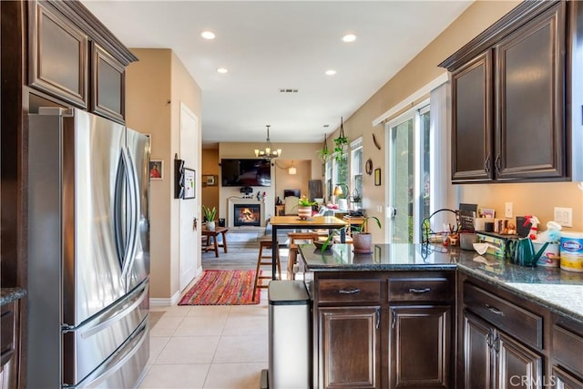 10460 Meadow Lark Ave, Moreno Valley, CA 92557 - kitchen with freestanding refrigerator, dark brown cabinetry, recessed lighting, light tile patterned flooring, and a chandelier