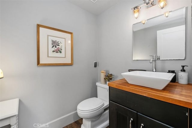 19172 Sierra Maria Rd, Irvine, CA 92603 - half bathroom featuring vanity, toilet, baseboards, and wood finished floors