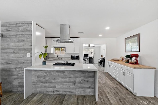 28799 Murrieta Rd, Menifee, CA 92586 - kitchen featuring island range hood, a sink, gas cooktop, white cabinetry, and wood finished floors