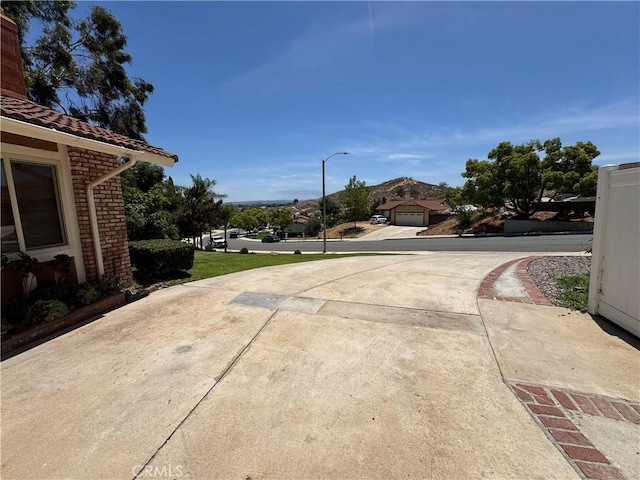 4787 Boardwalk Dr, Riverside, CA 92503 - view of concrete driveway featuring street lighting and a mountain view