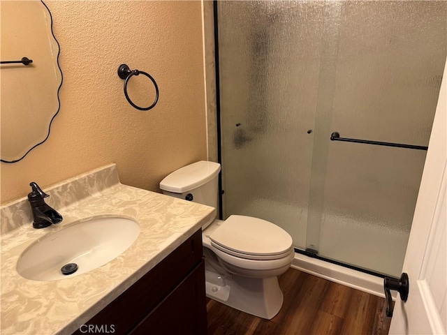 4787 Boardwalk Dr, Riverside, CA 92503 - bathroom with wood finished floors, vanity, a shower with door, toilet, and a textured wall