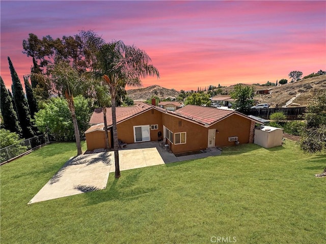 4787 Boardwalk Dr, Riverside, CA 92503 - back of property at dusk featuring stucco siding, a patio area, and a tile roof