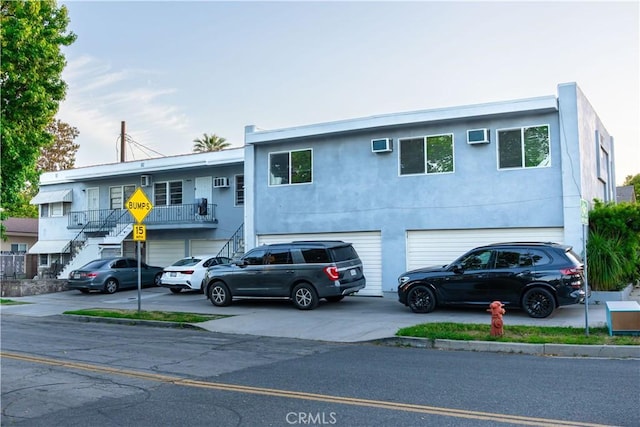 1341 N Keystone St, Burbank, CA 91506 - townhome / multi-family property featuring stairway, an attached garage, concrete driveway, stucco siding, and a wall unit AC