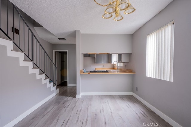 1341 N Keystone St, Burbank, CA 91506 - kitchen featuring a chandelier, light wood finished floors, a textured ceiling, and light countertops