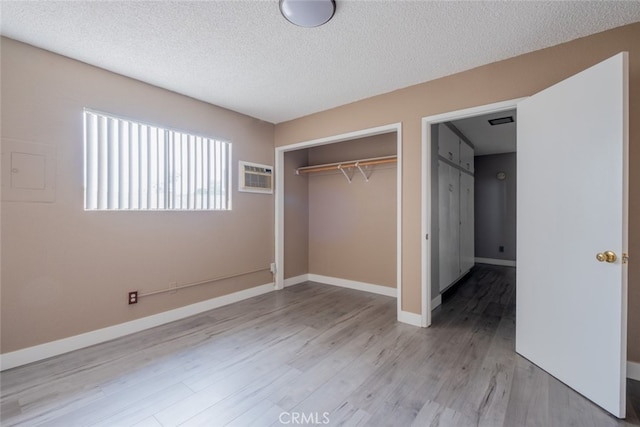 1341 N Keystone St, Burbank, CA 91506 - unfurnished bedroom with a textured ceiling, a closet, a wall mounted air conditioner, and light wood finished floors