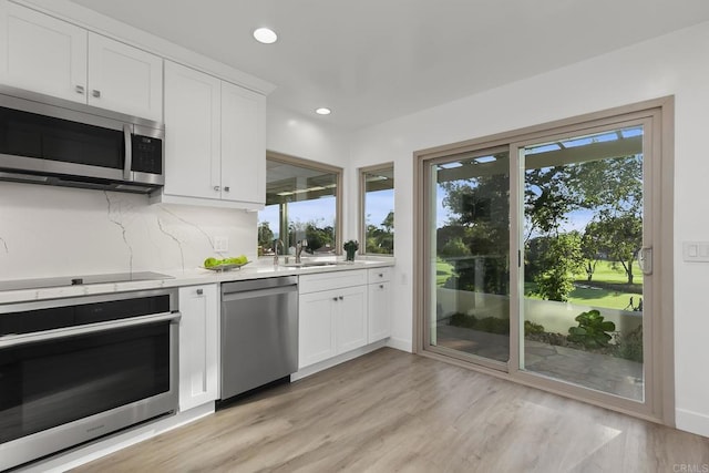 17636 Plaza Arica, San Diego, CA 92128 - kitchen featuring appliances with stainless steel finishes, light countertops, recessed lighting, white cabinetry, and light wood-type flooring