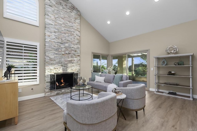 17636 Plaza Arica, San Diego, CA 92128 - living room with high vaulted ceiling, wood finished floors, a stone fireplace, baseboards, and recessed lighting