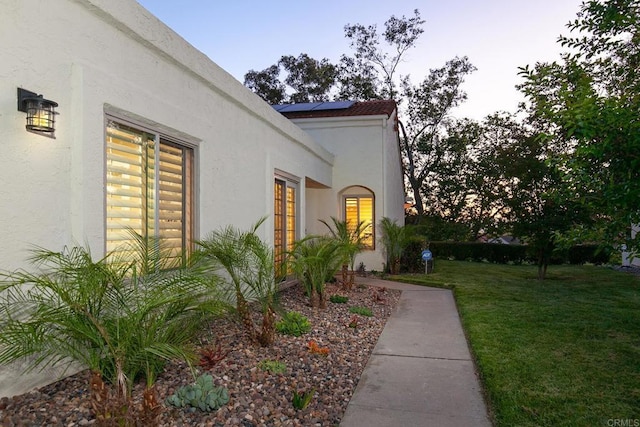 17636 Plaza Arica, San Diego, CA 92128 - view of property exterior featuring stucco siding, a yard, and solar panels