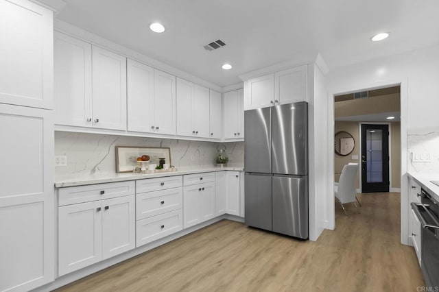 17636 Plaza Arica, San Diego, CA 92128 - kitchen featuring freestanding refrigerator, light wood-type flooring, white cabinets, recessed lighting, and tasteful backsplash