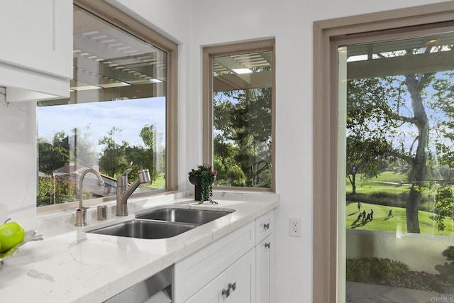 17636 Plaza Arica, San Diego, CA 92128 - kitchen featuring a sink, white cabinetry, light stone counters, and healthy amount of natural light
