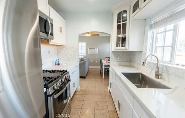 1390 Gundry Ave, Long Beach, CA 90813 - kitchen featuring stainless steel appliances, a sink, arched walkways, tasteful backsplash, and light countertops