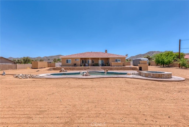 58598 Santa Maria Dr, Yucca Valley, CA 92284 - back of house featuring a mountain view, a patio, an outdoor hot tub, and a chimney