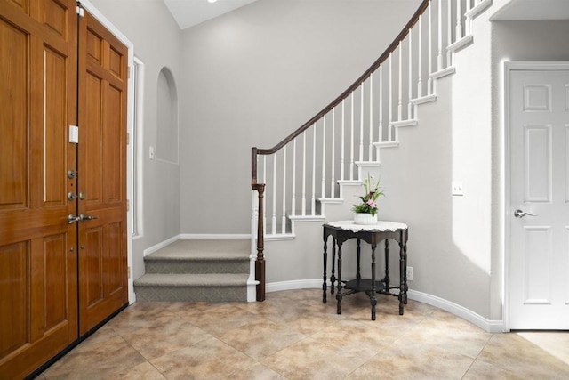 1990 Willowbrook Dr, Oceanside, CA 92056 - foyer entrance featuring arched walkways, stairway, light tile patterned flooring, and baseboards
