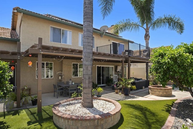 1990 Willowbrook Dr, Oceanside, CA 92056 - back of house featuring a balcony, stucco siding, a patio area, an outdoor living space with a fire pit, and a lawn