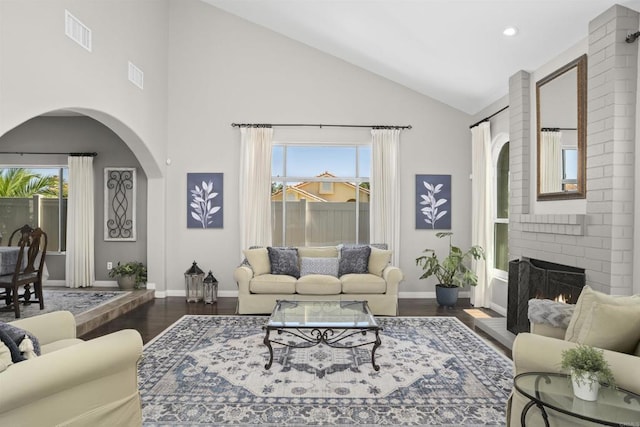1990 Willowbrook Dr, Oceanside, CA 92056 - living area with high vaulted ceiling, wood finished floors, a fireplace, arched walkways, and baseboards
