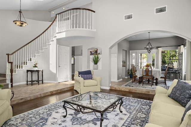 1990 Willowbrook Dr, Oceanside, CA 92056 - living area featuring hardwood / wood-style flooring, arched walkways, high vaulted ceiling, a chandelier, and stairway