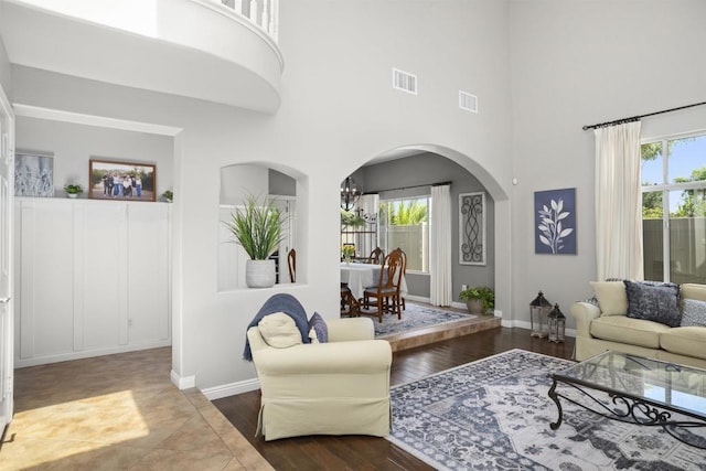 1990 Willowbrook Dr, Oceanside, CA 92056 - living room with a high ceiling, plenty of natural light, arched walkways, wood finished floors, and baseboards