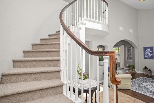 1990 Willowbrook Dr, Oceanside, CA 92056 - stairs featuring arched walkways, a towering ceiling, wood finished floors, and baseboards