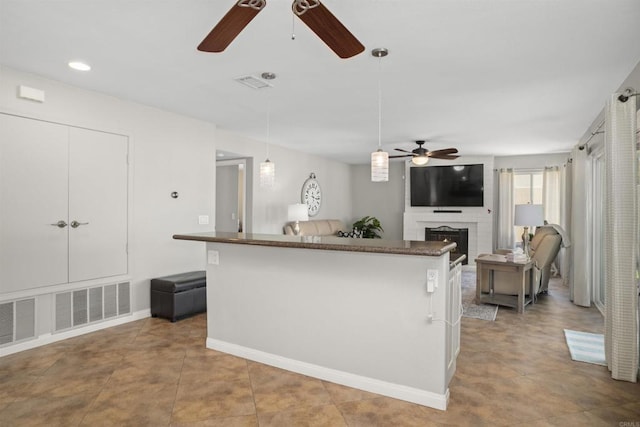 1990 Willowbrook Dr, Oceanside, CA 92056 - kitchen with a ceiling fan, a fireplace, hanging light fixtures, dark countertops, and recessed lighting