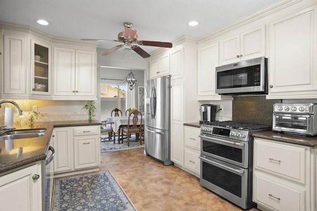1990 Willowbrook Dr, Oceanside, CA 92056 - kitchen featuring stainless steel appliances, a sink, dark countertops, ceiling fan, and white cabinetry