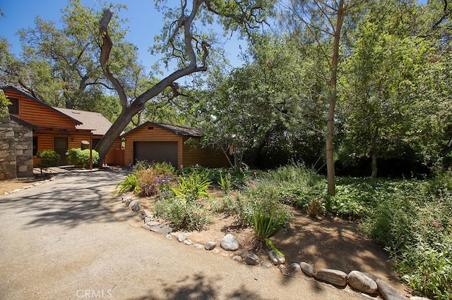 2057 Oakwood St, Pasadena, CA 91104 - view of front of home featuring log veneer siding, a garage, and driveway