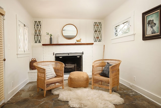 2057 Oakwood St, Pasadena, CA 91104 - sitting room featuring stone tile floors, baseboards, and a brick fireplace
