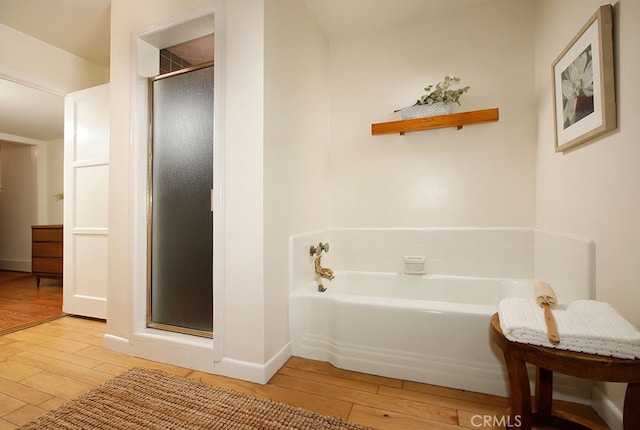 2057 Oakwood St, Pasadena, CA 91104 - bathroom featuring wood-type flooring, a stall shower, a garden tub, and baseboards