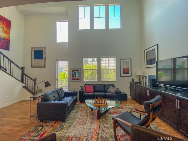 5 Abarrota St, Rancho Mission Viejo, CA 92694 - living room with wood finished floors, a high ceiling, stairs, and baseboards
